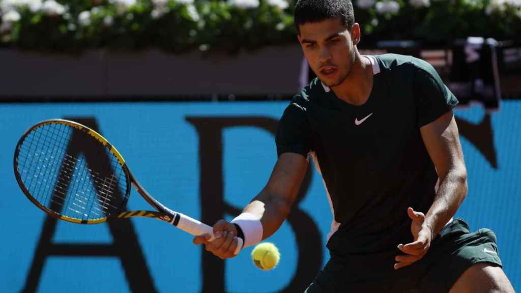 Carlos Alcaraz intenta hacer una dejada ante Novak Djokovic en el Mutua Madrid Open