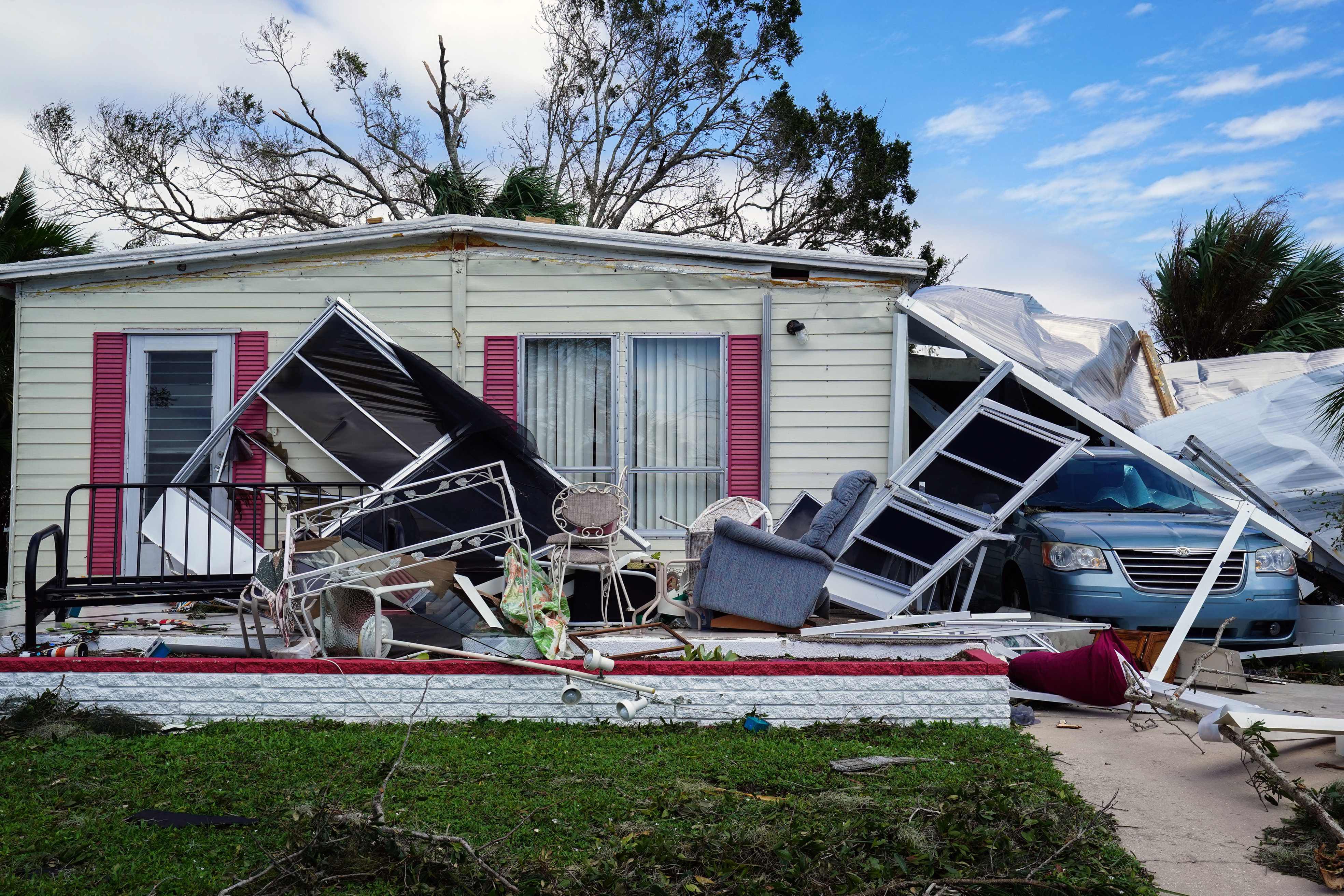 Un techo se derrumba sobre una minivan después del huracán Ian en Marylu Park, Charlotte Harbor, Florida, el 29 de septiembre de 2022. (Foto de Bryan R. Smith / AFP)