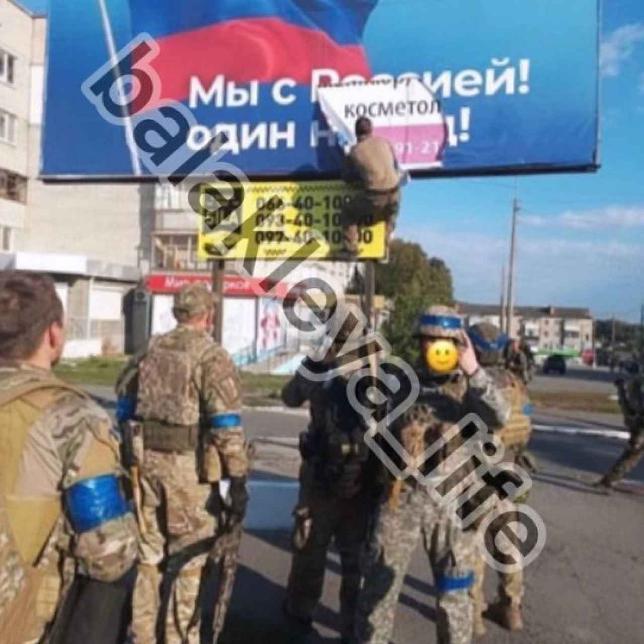 Un soldado ucraniano arranca un cartel con propaganda rusa en la ciudad de Balakliya.