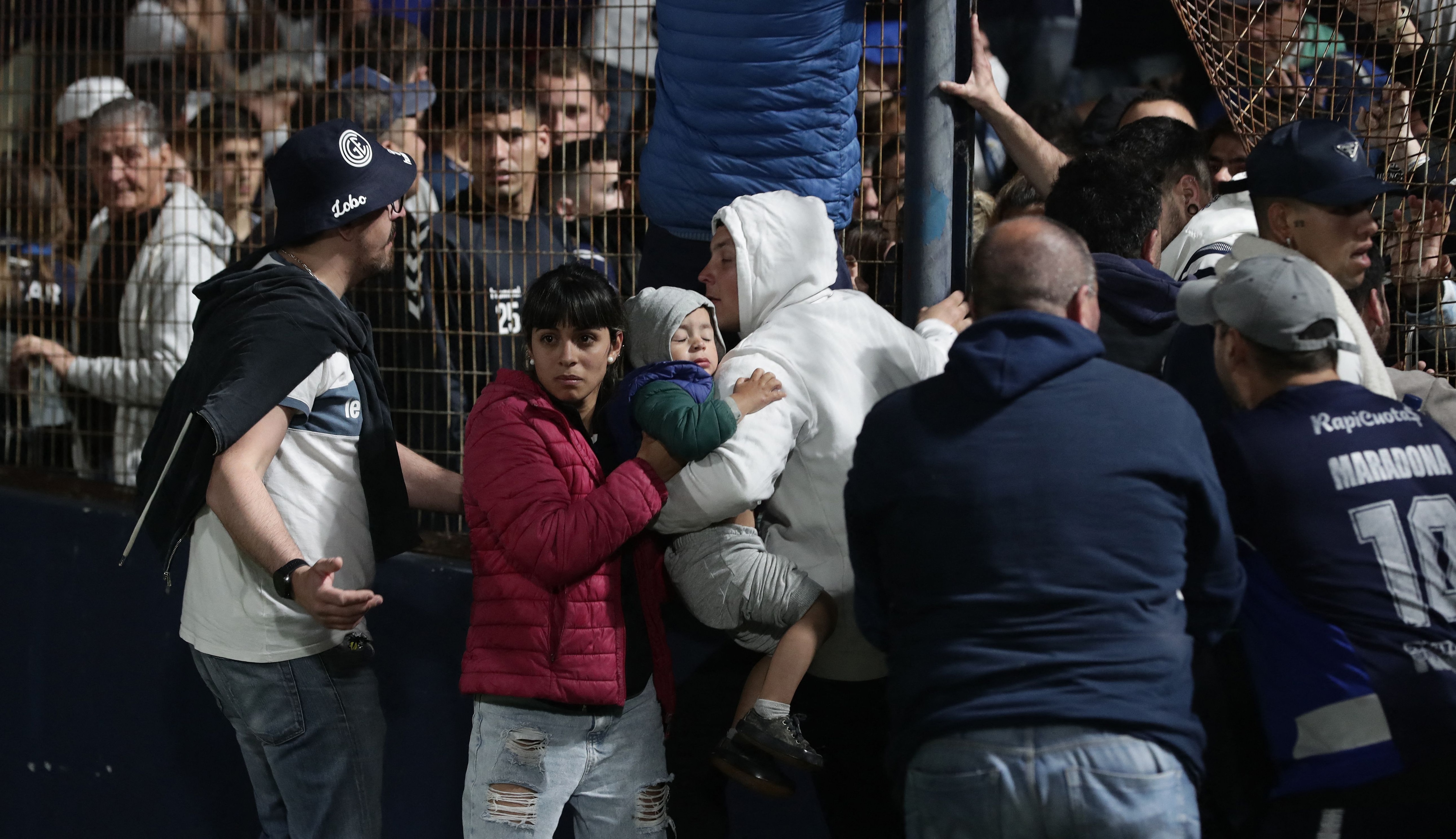 Los fanáticos reaccionan después de que la policía disparara gases lacrimógenos e ingresara al estadio Juan Carmelo Zerillo durante el partido entre Gimnasia y Esgrima y Boca Juniors el 6 de octubre de 2022. (Foto de ALEJANDRO PAGNI / AFP)