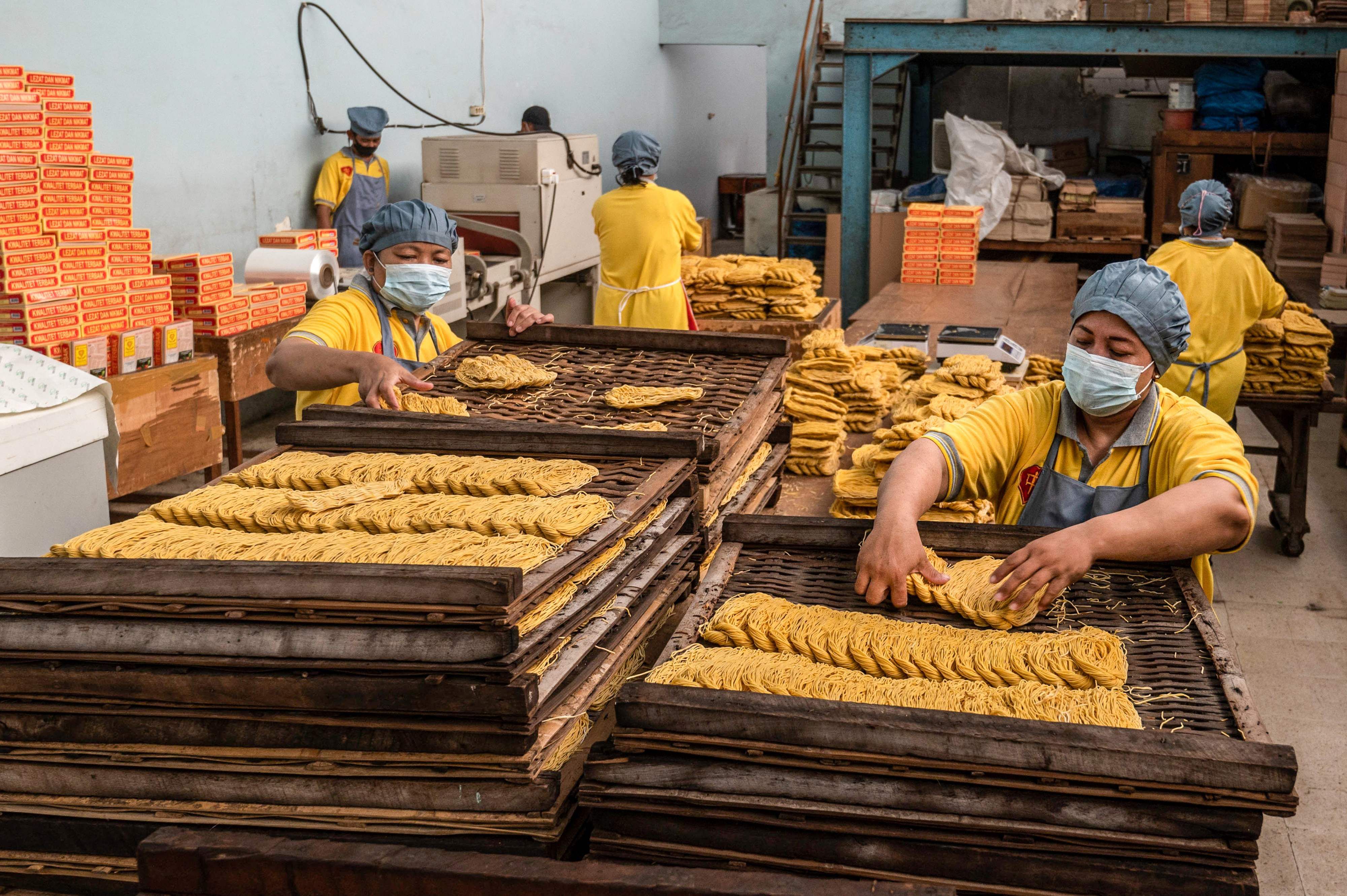 Un grupo de trabajadores producen fideos en una fábrica en Surabaya, Indonesia. Fotografía con fines ilustrativos: