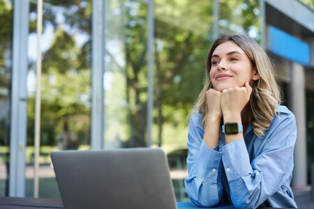 Chica joven ante ordenador en el exterior, pensando en el futuro. Tener un propósito es fundamental para reducir el burnout.