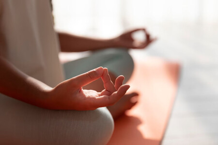 Persona meditando con las piernas cruzadas. Hay actividades que reducen el burnout, nos gusten o no.