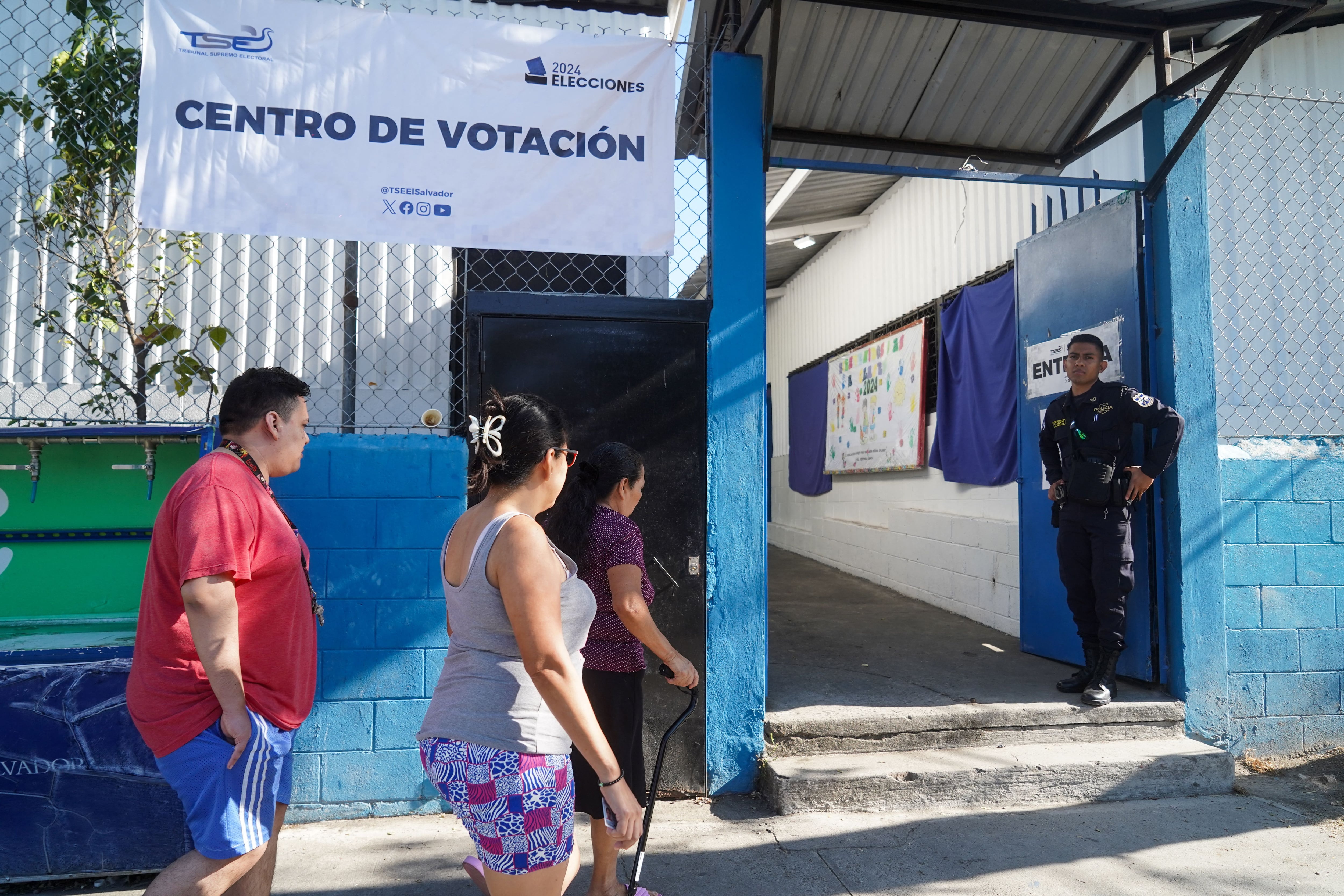 Un oficial de policía vigila un colegio electoral durante las elecciones presidenciales y legislativas en el barrio La Campanera en Soyapango, El Salvador.